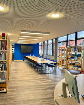 Blick in die Bibliothek mit Bücherregalen und Lesetisch im Rathaus Trusetal.