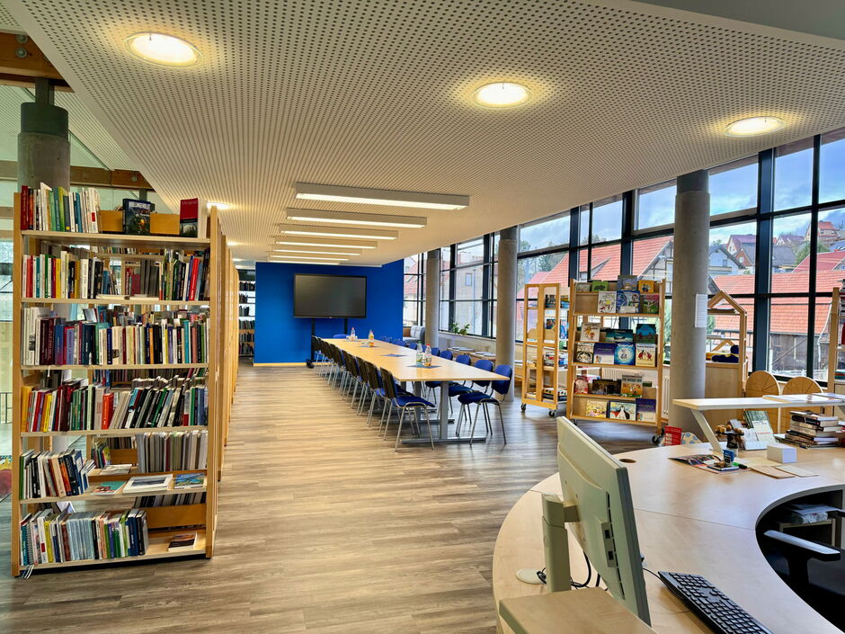 Blick in die Bibliothek mit Bücherregalen und Lesetisch im Rathaus Trusetal.